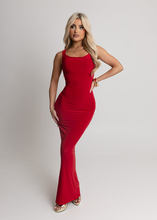Women's red slinky fabric maxi dress with cut out back and red satin bow attachment. Model is 5ft2' and wears a size XS 6.