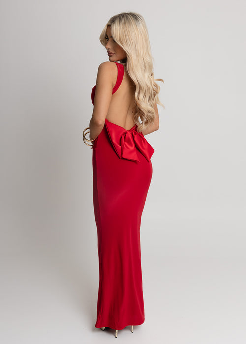 Women's red slinky fabric maxi dress with cut out back and red satin bow attachment. Model is 5ft2' and wears a size XS 6.