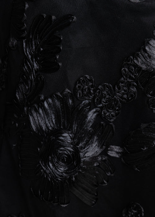 Black embroidered detail of 3-D flowers on swatch