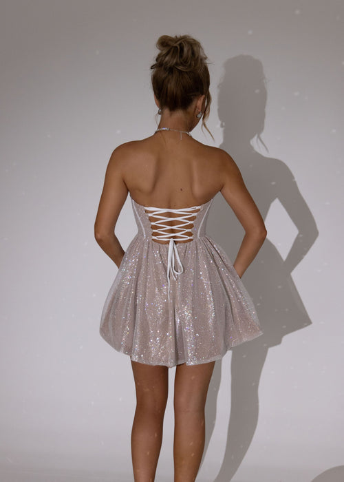 Women's strapless mini dress in champagne iridescent glitter fabric. Glitter scallop cups with corset boning in the bodice and puffball waistline. Model is 5ft6' and wears a size S