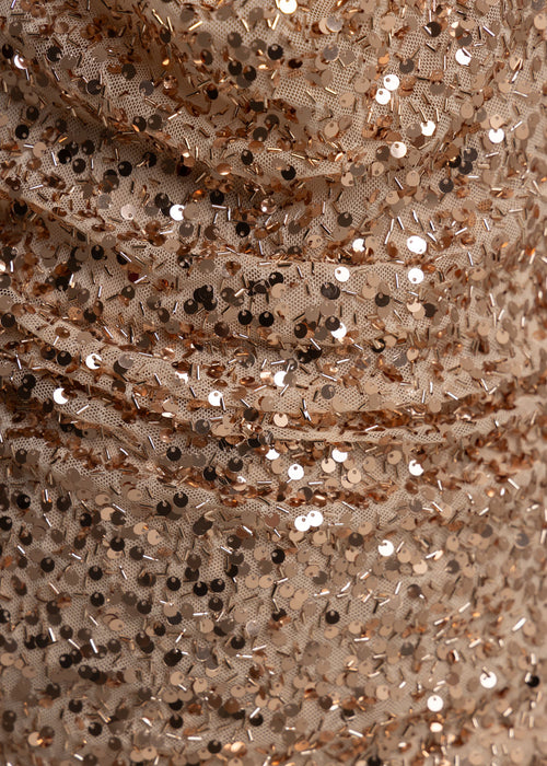 Close up swatch of fabric showing rose gold sequins and rose gold small beads embellished in the fabric.