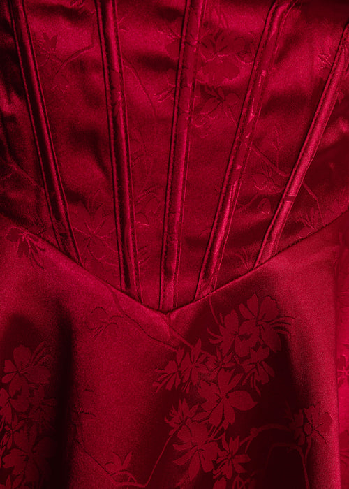 Women's red satin strapless mini dress with corset style bodice and floaty fit. Model is 5ft2' and wears a size XS.