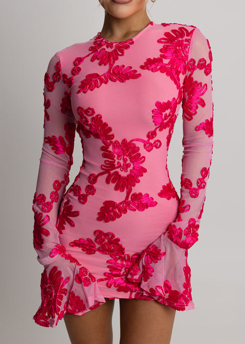 Women's pink mini dress with long sleeves and flared cuffs. 3D floral embroidery embellished throughout fabric. Model is 5ft2' and wears a size XS 6.