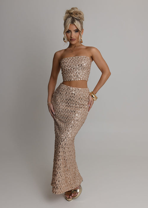 Women's rose gold embellished two piece set with bandeau style crop top fully embellished with sequins and a high waist rose gold maxi skirt fully embellished with sequins. Model is 5ft2' and wears a size XS 6.