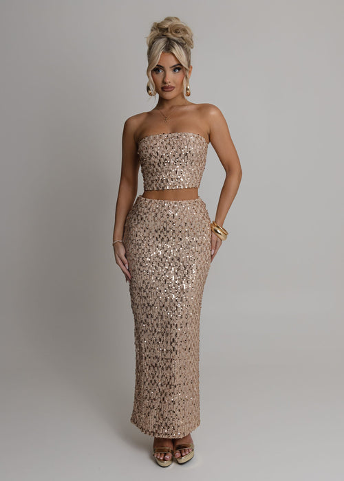 Women's rose gold embellished two piece set with bandeau style crop top fully embellished with sequins and a high waist rose gold maxi skirt fully embellished with sequins. Model is 5ft2' and wears a size XS 6.
