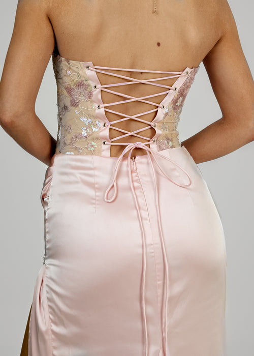 Women's corset pink prom gown with embellished corset and satin skirt with thigh slit. Strapless design and figure hugging fit.