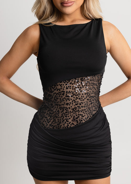 Women's little black dress with cutout midriff lined with mesh and black sparkly sequins. Mini dress is a bodycon fit with high scoop neck. Model is 5ft2' and wears a size XS 6.