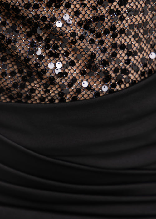 Women's little black dress with cutout midriff lined with mesh and black sparkly sequins. Mini dress is a bodycon fit with high scoop neck. Model is 5ft2' and wears a size XS 6.