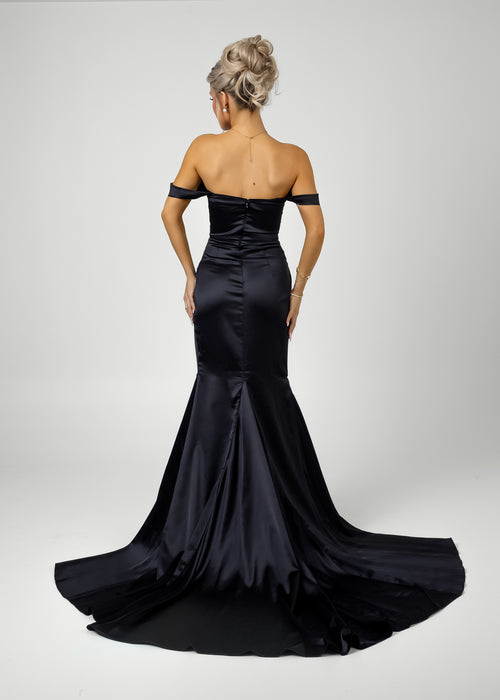 Women's black satin bardot prom gown with thigh high slit and ruched detailing along the waist.
