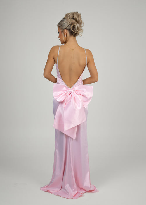 Women's pink elegant ball gown dress features a low plunge back with a sparkling diamante trim, a statement bow detail, and a flattering fishtail silhouette. Made from pink soft stretch satin fabric that hugs your curves for a glamourous look.