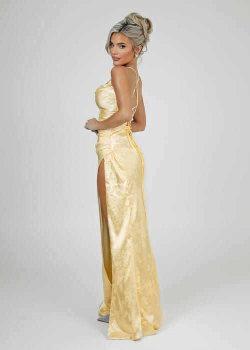 Women's pastel yellow satin prom gown with thigh slit and spaghetti style straps. Figure hugging fit. 