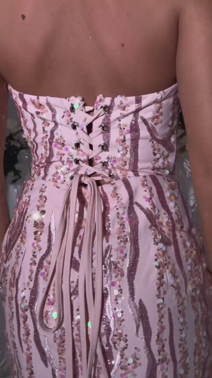 Women's pink embellished mini dress with strapless design and a bodycon fit. Fully embellished with pink feathers, pink sequins and pink glitters. Model is 5ft2' and wears a size XS 6.